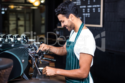 Smiling waiter making cup of coffee