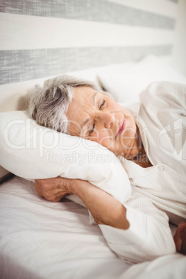 Senior woman sleeping on bed