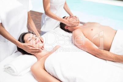 Couple receiving a face massage from masseur