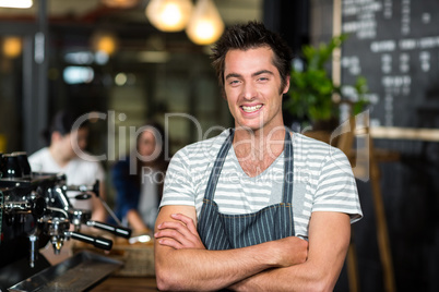 Smiling barista with arms crossed