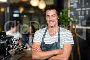 Smiling barista with arms crossed