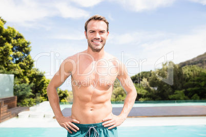 Young man smiling near poolside