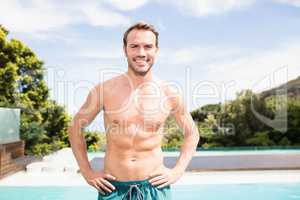 Young man smiling near poolside