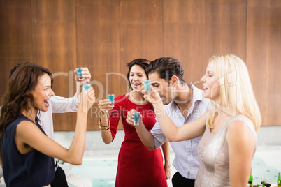 Young and handsome group of friends drinking shots