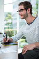 Handsome man working on computer and taking notes