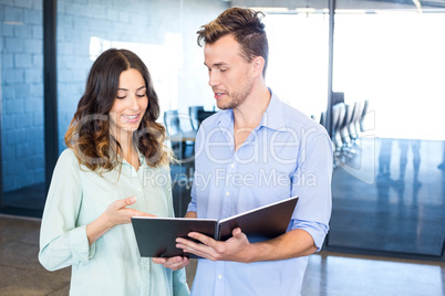 Businessman and businesswoman interacting holding organizer