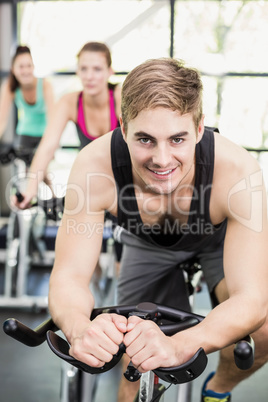 Fit group of people using exercise bike together