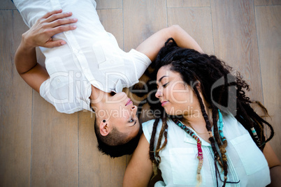 Lesbian couple lying on wooden floor