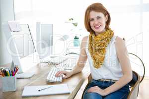 smiling hipster businesswoman sitting at her desk