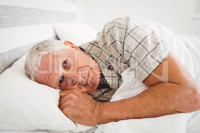 Sick senior man lying on bed