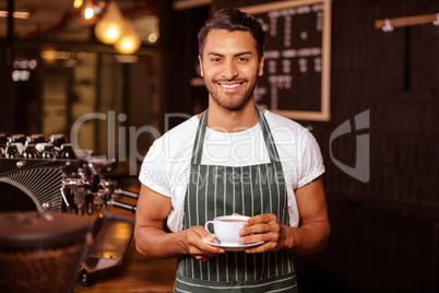 Smiling barista holding coffee