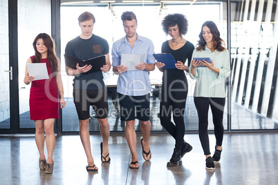 Colleagues standing with document and digital tablet