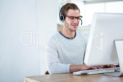 Handsome man working on computer with headset