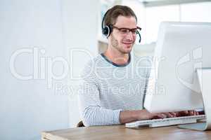 Handsome man working on computer with headset