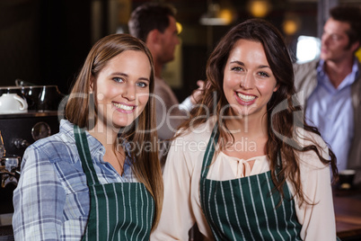 Pretty baristas smiling at the camera