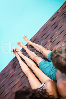 Young couple sitting by poolside