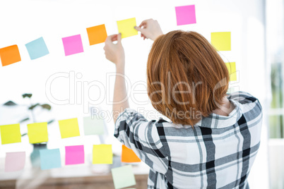 hipster woman sticking up coloured paper squares
