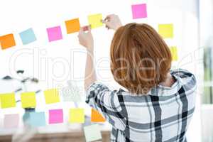 hipster woman sticking up coloured paper squares