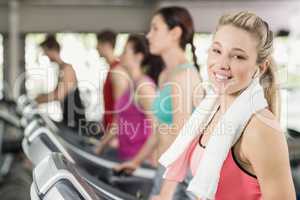 Fit woman running on the treadmill while listening music