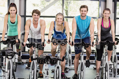 Fit group of people using exercise bike together