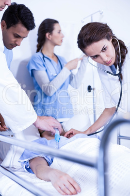 Doctors examining a patient on bed