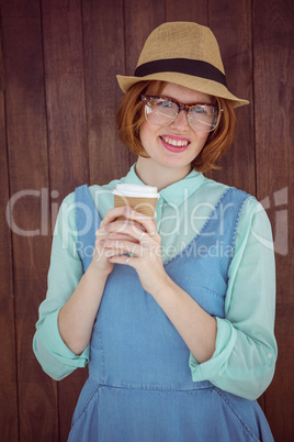 Cute red haired hipster with glasses holding disposable cup