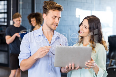 Colleagues discussing on laptop in office