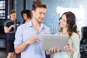 Colleagues discussing on laptop in office