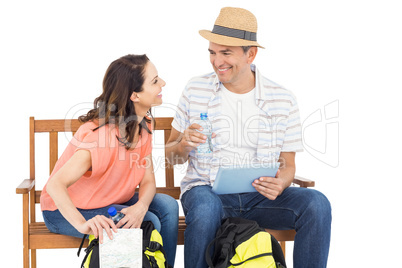 Couple on bench using tablet