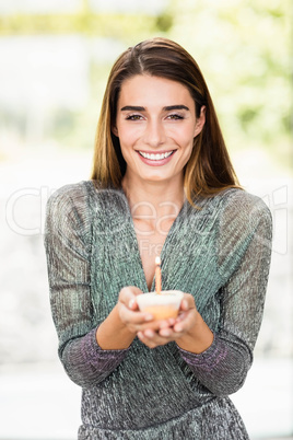 Beautiful woman holding birthday cupcake
