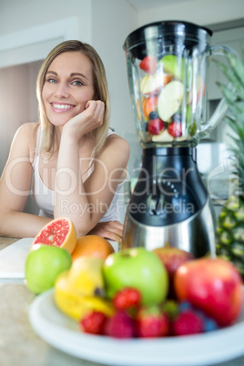 Pretty blonde woman happy to prepare a smoothie