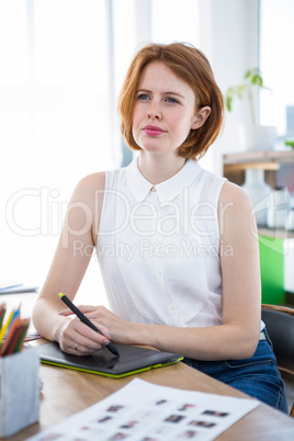 thoughtful hipster businesswoman with a digital drawing tablet