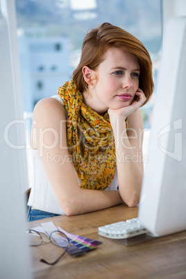 thoughtful hipster businesswoman concentrating on her computer