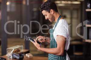 Smiling barista using tablet