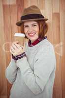 smiling hipster woman in a hat, holding a coffee