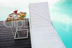 Tray with breakfast in side table and sun lounger