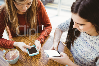 Friends using smartphone and having coffee