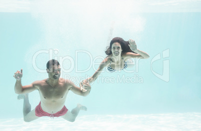Couple enjoying underwater in swimming pool