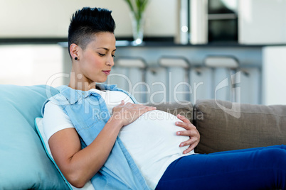 Pregnant woman relaxing on sofa in living room