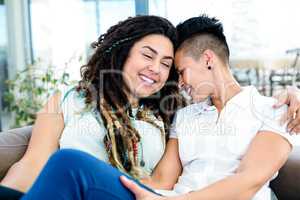 Happy lesbian couple relaxing on sofa