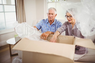 Senior couple unpacking a cardboard box