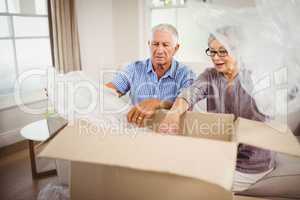 Senior couple unpacking a cardboard box