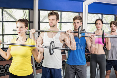 Fitness class lifting barbell