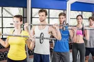 Fitness class lifting barbell