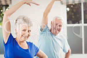 Portrait of senior couple performing stretching exercise
