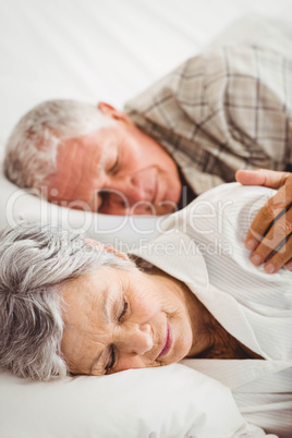 Senior couple sleeping on bed