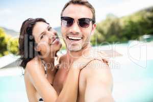Young couple smiling near pool