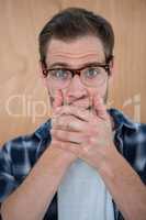 Handsome hipster surprised with hands on mouth