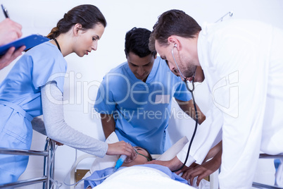 Doctors examining a patient on bed