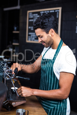 Smiling waiter making cup of coffee